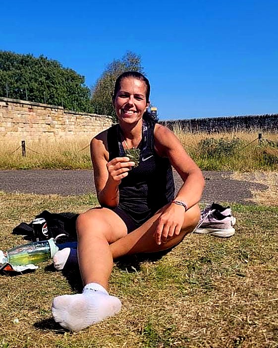 Patrycja after finishing a half marathon, holding her medal